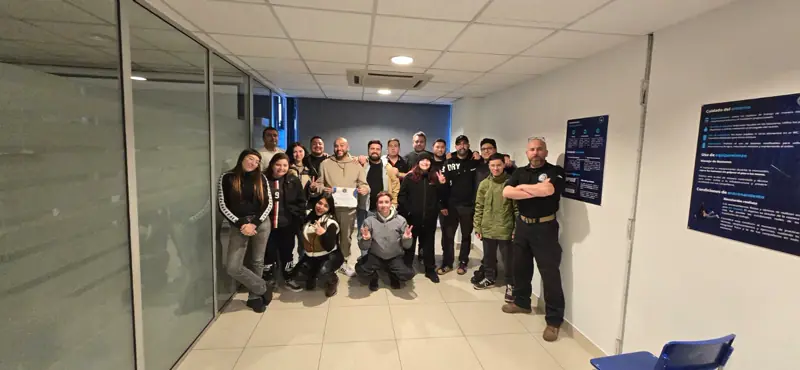 Grupo de alumnos e instructores de ZCAP reunidos en el pasillo de la sede.
