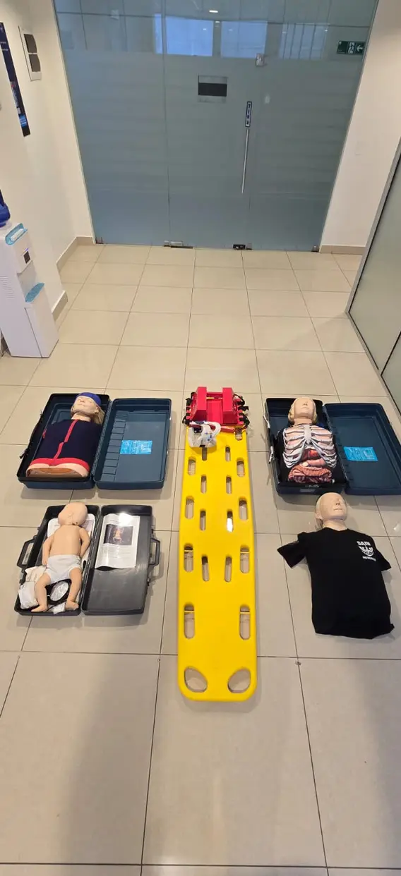Equipo de práctica: tabla espinal, maniquíes y bolsos de primeros auxilios.