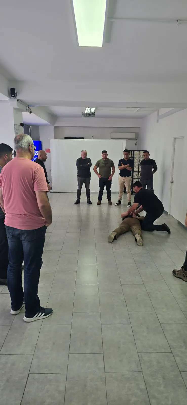 Instructor demuestra una técnica de control en el suelo.